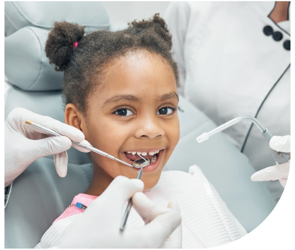 dentista infantil a examinar dentes de criança