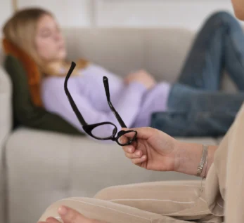 Pessoa deitada num sofá a ouvir o psicólogo durante uma sessão de psicologia.